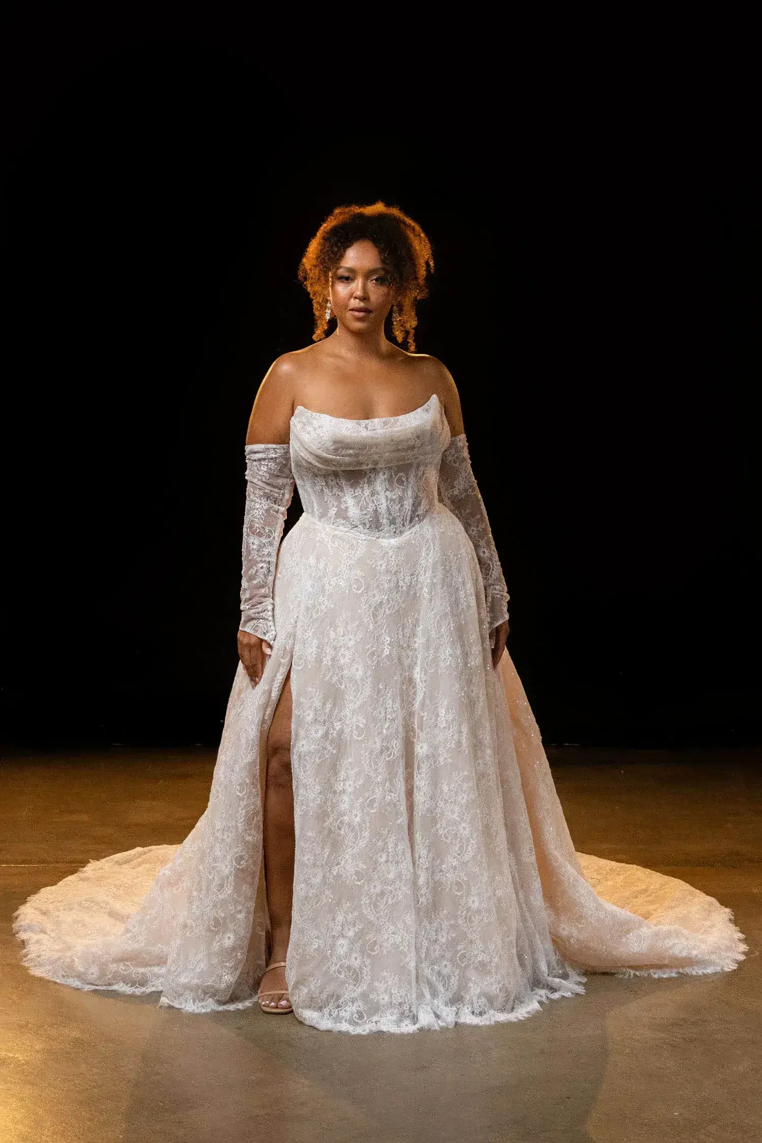 model is wearing a strapless bridal gown with detachable gauntlet sleeves