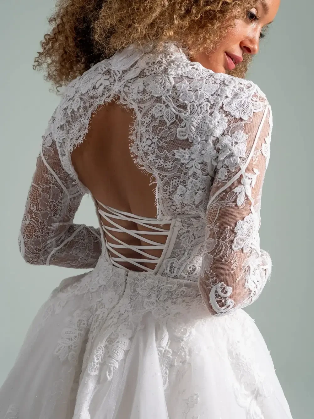 model is wearing a lace long sleeve bridal gown