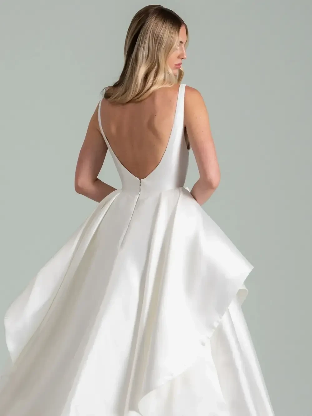 model is wearing a sleeveless tiered skirt wedding dress