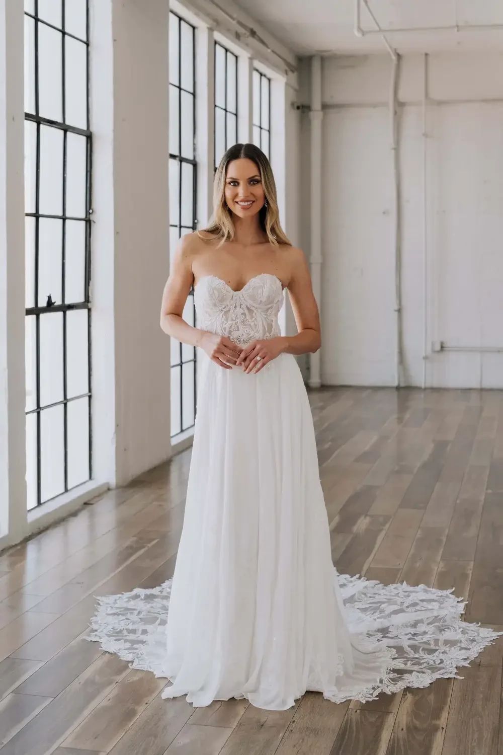 model is wearing a sleeveless chiffon wedding dress