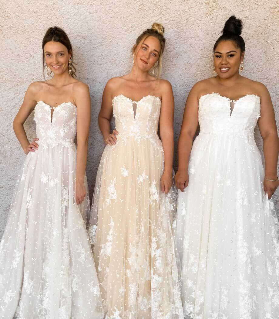 Models wearing a white bridal gowns
